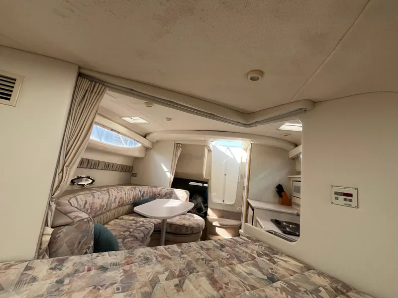 Slide: The Image of 1999 Bayliner 3055 Ciera cabin interior with seating, table, and kitchenette. - 7
