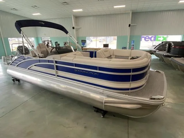 Slide: The Image of 2024 Bennington 23 RSB pontoon boat in showroom, blue and white exterior. - 3