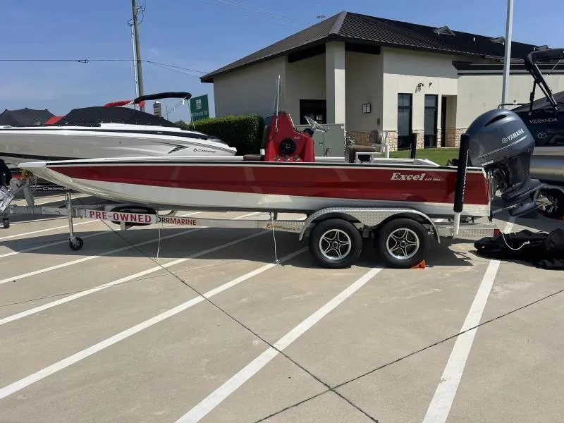Slide: The Image of 2023 Excel Boats 220 Bay Pro, red and white, on trailer in parking lot. - 5