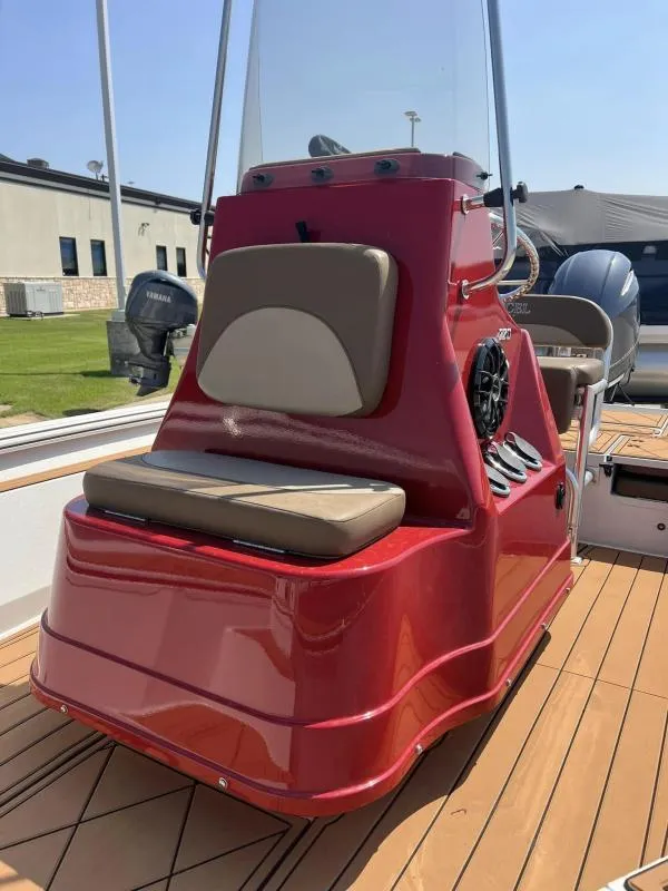 Slide: The Image of 2023 Excel Boats 220 Bay Pro, red console with seating, on a wooden deck. - 8