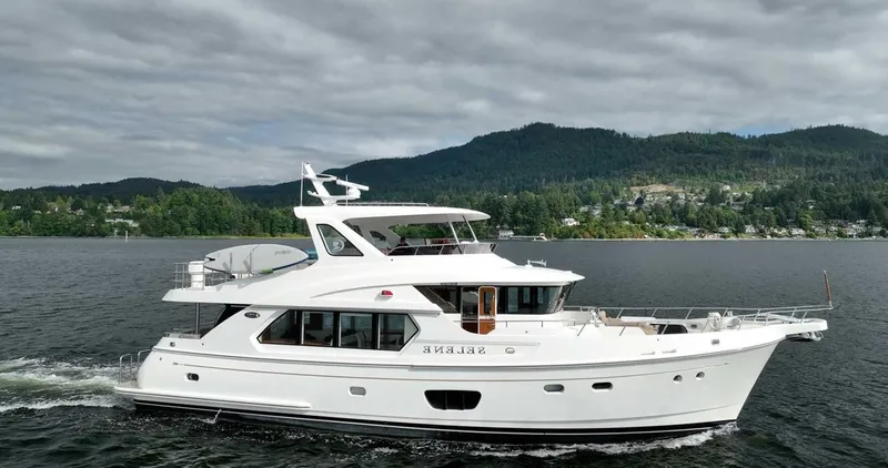 Slide: The Image of 2026 Selene 60 Ocean Explorer yacht cruising on a scenic lake with forested hills. - 2