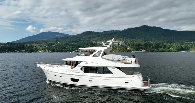 Slide: The Image of 2026 Selene 60 Ocean Explorer yacht cruising on a scenic lake with forested hills. - 3