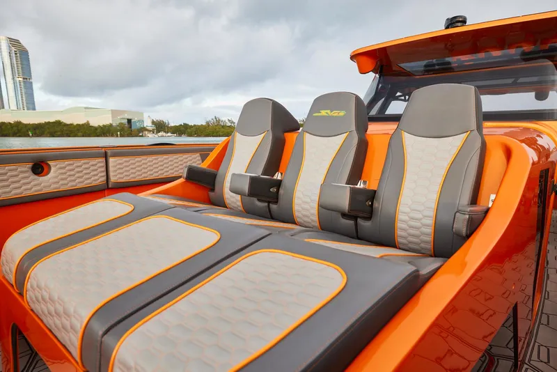 Slide: The Image of 2023 Midnight Express 43' Solstice boat with sleek orange and gray seating design. - 11