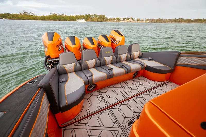 Slide: The Image of 2023 Midnight Express 43' Solstice boat with orange seating and powerful engines on a lake. - 17