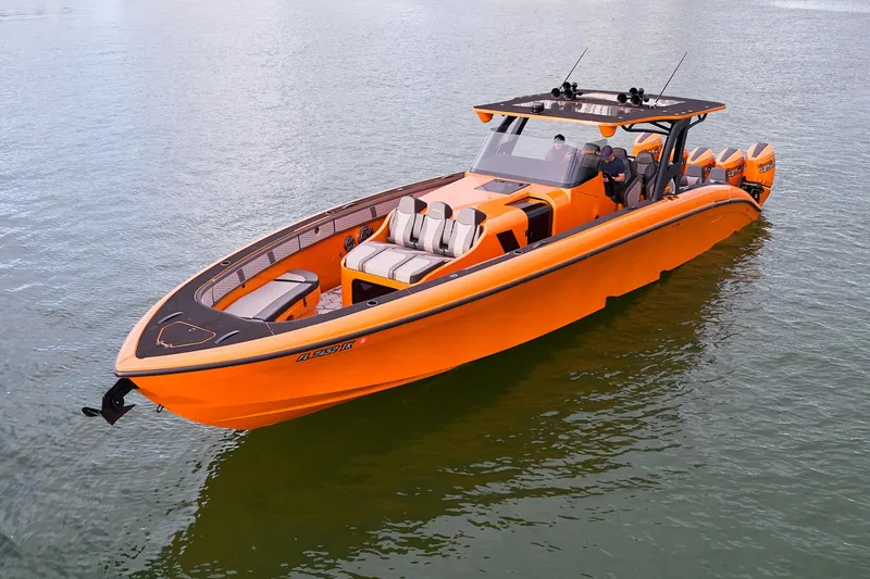 Slide: The Image of 2023 Midnight Express 43' Solstice boat in vibrant orange on calm water. - 6
