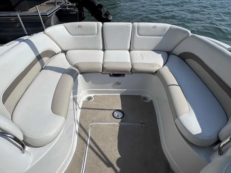 Slide: The Image of 2010 Crownline 240 LS boat interior with cushioned seating and carpeted floor. - 11