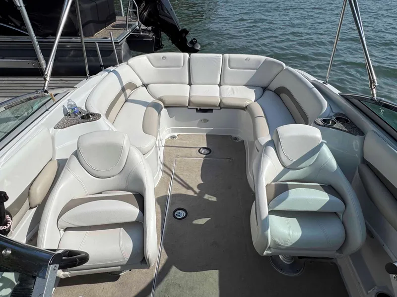 Slide: The Image of 2010 Crownline 240 LS boat interior with plush seating and cup holders on a sunny day. - 6