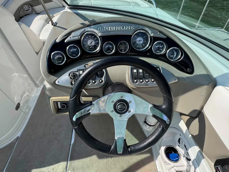 Slide: The Image of Steering wheel and dashboard of 2010 Crownline 240 LS boat, featuring gauges and controls. - 8