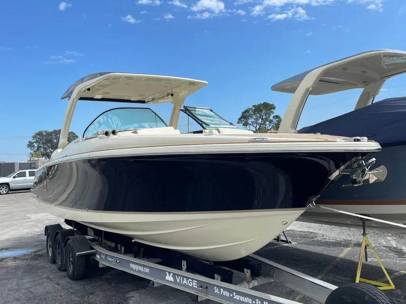 Slide: The Image of 2024 Chris-Craft Launch 31 GT boat on a trailer under a clear blue sky. - 1