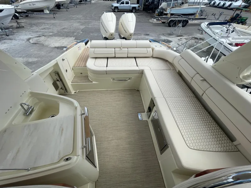 Slide: The Image of 2024 Chris-Craft Launch 31 GT boat interior with beige seating and twin outboard engines. - 7