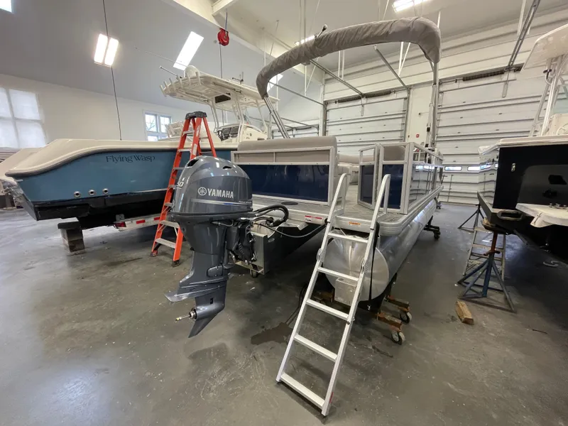 Slide: The Image of 2024 Godfrey Xperience 1880 FX pontoon boat in a garage with Yamaha outboard motor. - 19