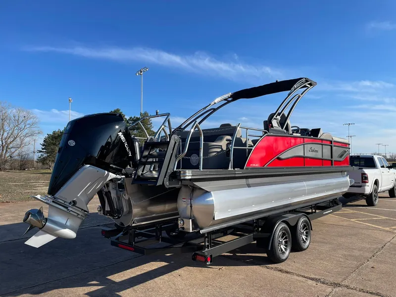 Slide: The Image of 2024 Barletta CORSA 23UCA pontoon boat with red and black accents on a trailer. - 11