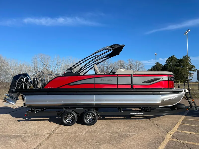 Slide: The Image of 2024 Barletta CORSA 23UCA pontoon boat with red and silver exterior on a trailer. - 13