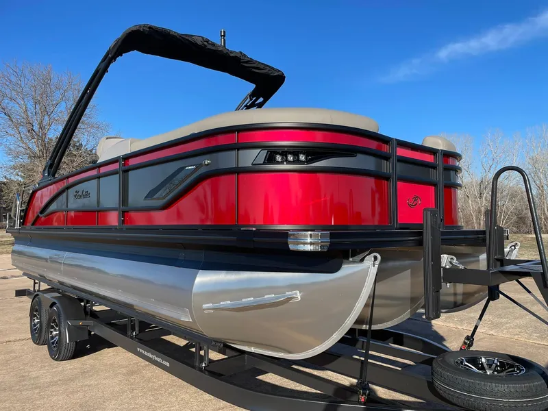 Slide: The Image of 2024 Barletta CORSA 23UCA pontoon boat on a trailer, red and black exterior. - 15