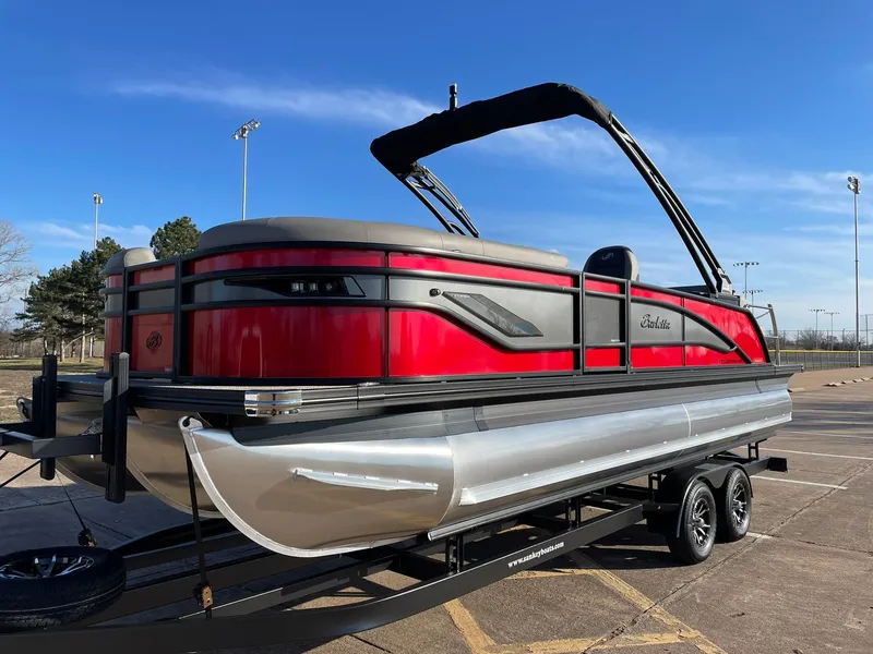 Slide: The Image of 2024 Barletta CORSA 23UCA pontoon boat in red and black on a trailer. - 4