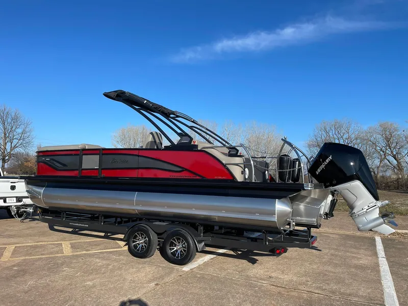 Slide: The Image of 2024 Barletta CORSA 23UCA pontoon boat on a trailer in a parking lot. - 7