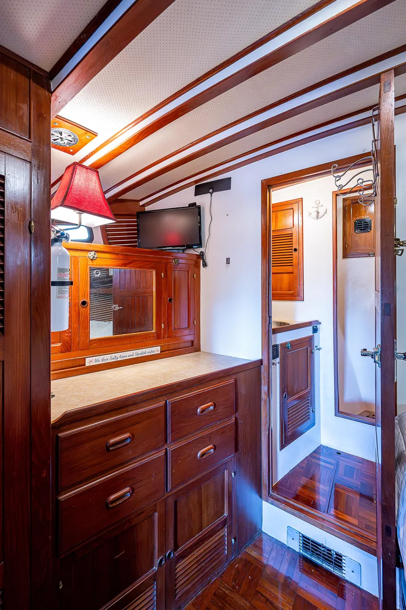 Slide: The Image of 1983 Krogen 42 yacht interior with wooden cabinetry, mirror, and TV. - 12
