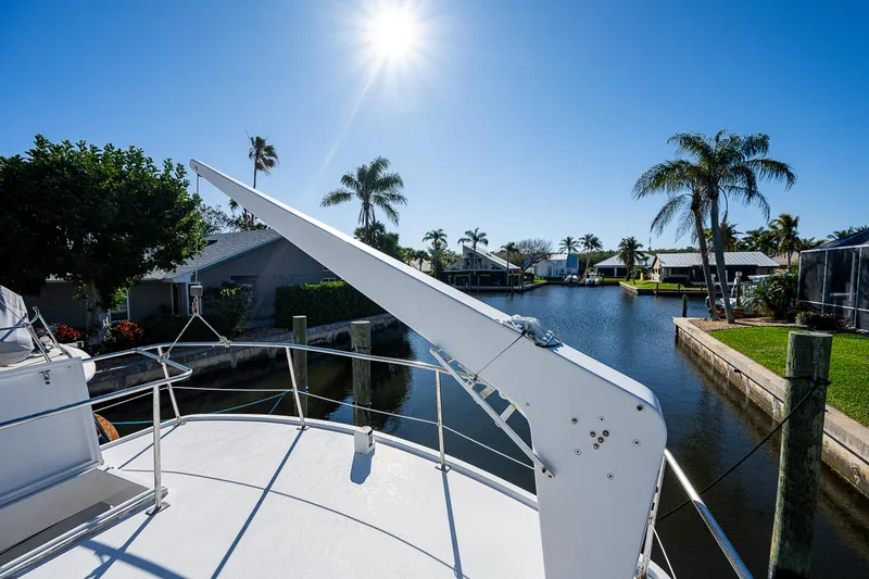 Slide: The Image of 1983 Krogen 42 yacht on a sunny day, docked near palm trees and waterfront homes. - 15