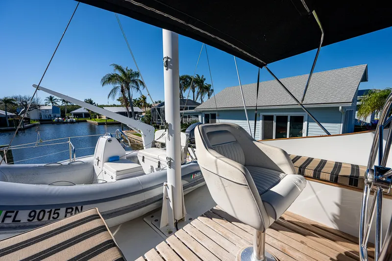 Slide: The Image of 1983 Krogen 42 yacht deck with seating, docked by waterfront homes and palm trees. - 17