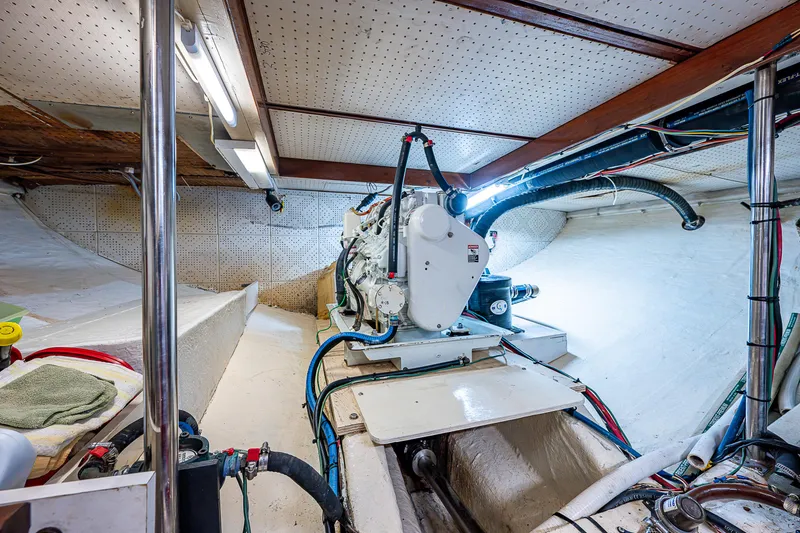 Slide: The Image of Engine room of a 1983 Krogen 42 boat, featuring mechanical components and wiring. - 20