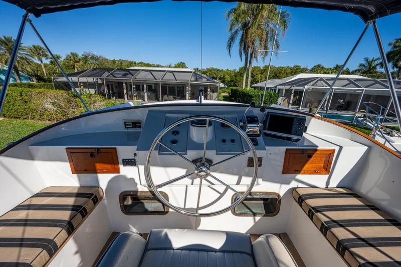 Slide: The Image of 1983 Krogen 42 boat helm with striped seating, steering wheel, and navigation equipment. - 28