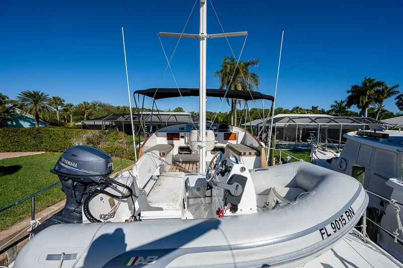 Slide: The Image of 1983 Krogen 42 yacht with inflatable boat and Yamaha motor, docked in a tropical setting. - 31