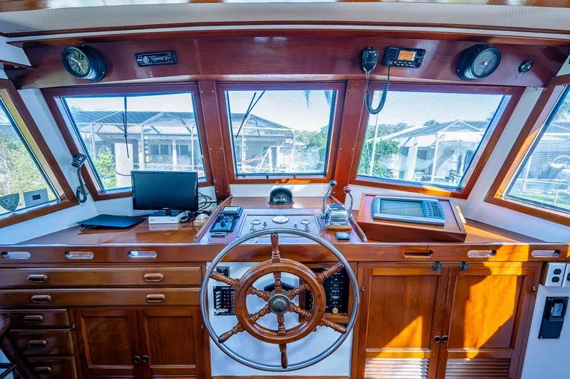 Slide: The Image of 1983 Krogen 42 boat helm with wooden steering wheel and navigation equipment. - 33