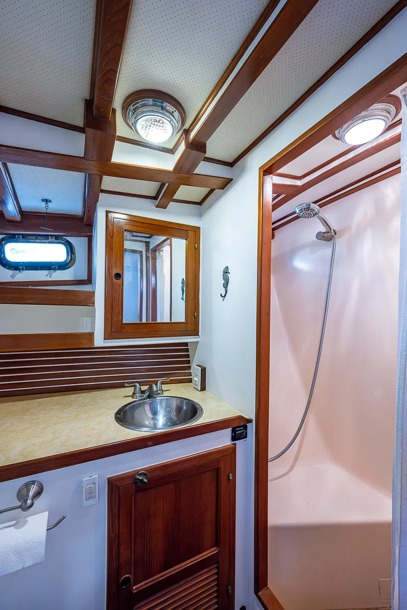 Slide: The Image of 1983 Krogen 42 yacht bathroom with wooden accents, sink, and shower. - 9