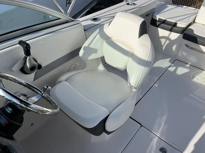 Slide: The Image of 2024 Robalo R207 Dual Console boat interior with white captain's chair and steering wheel. - 12