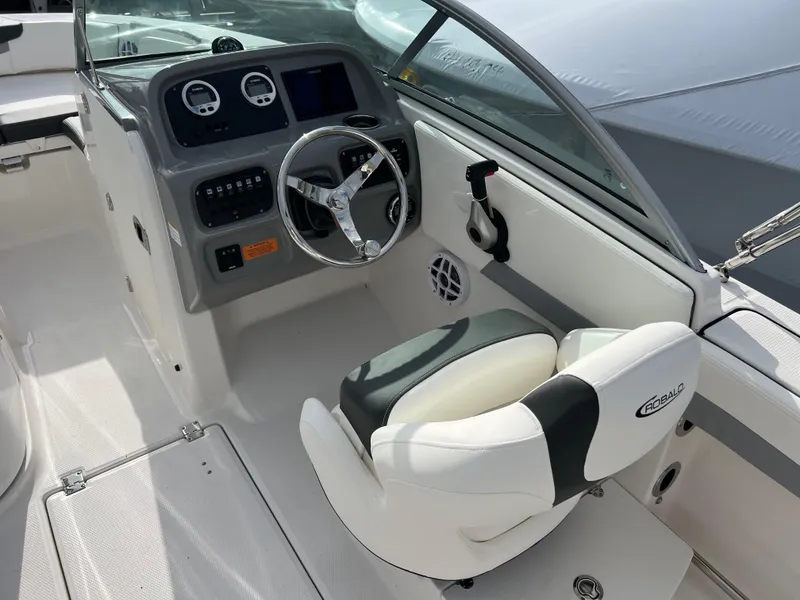 Slide: The Image of 2024 Robalo R207 Dual Console boat cockpit with steering wheel and captain's chair. - 4