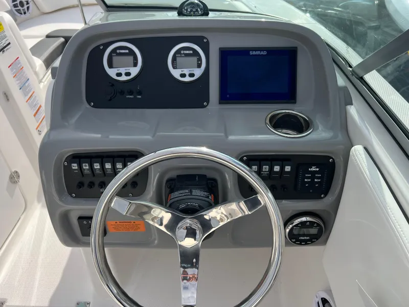 Slide: The Image of 2024 Robalo R207 Dual Console boat dashboard with steering wheel and control panel. - 5