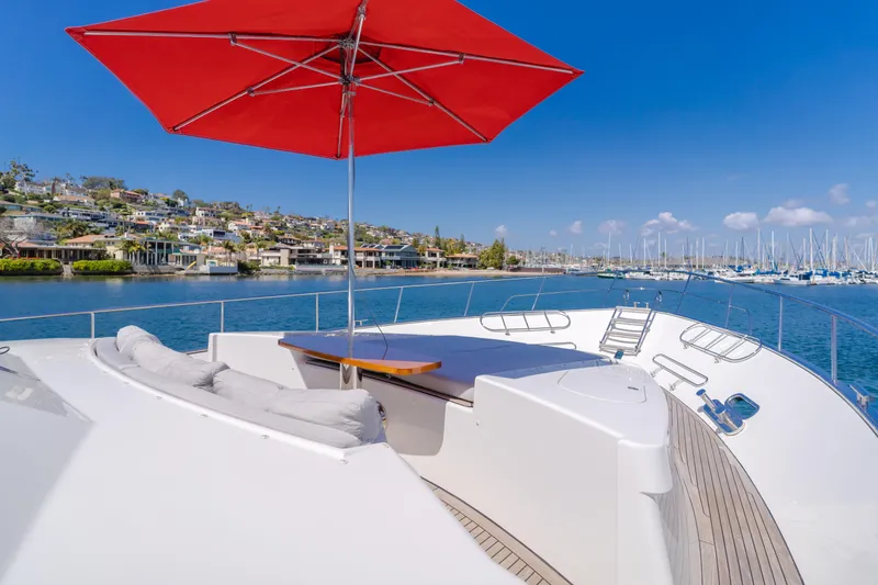 Slide: The Image of Flybridge deck of 2016 Van der Valk 78 Motor Yacht with red umbrella and scenic harbor view. - 19