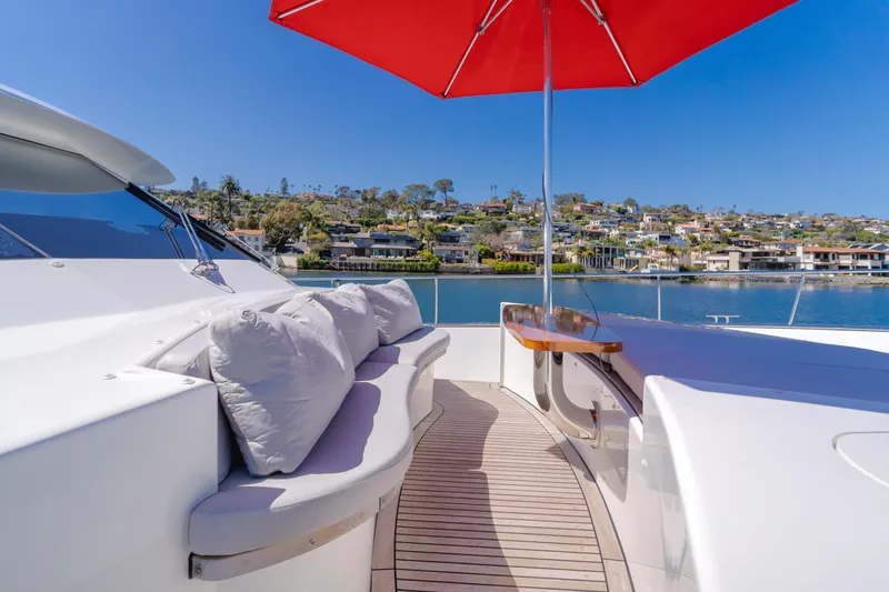Slide: The Image of Flybridge seating area on 2016 Van der Valk 78 Motor Yacht with red umbrella and waterfront view. - 20
