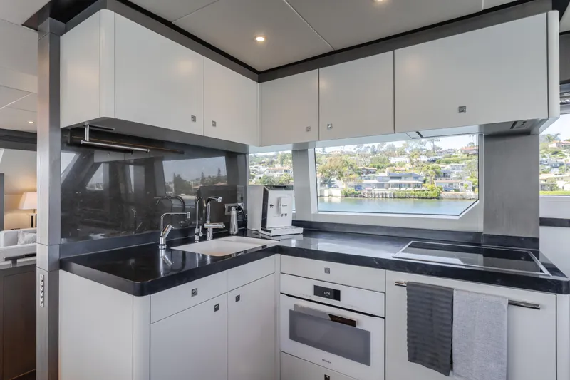 Slide: The Image of Modern kitchen on 2016 Van der Valk 78 Flybridge Motor Yacht with sleek black countertops. - 35
