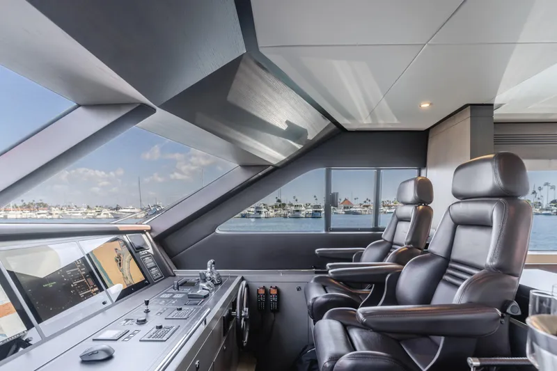 Slide: The Image of 2016 Van der Valk 78 Flybridge Motor Yacht helm station with leather captain chairs and panoramic windows. - 37