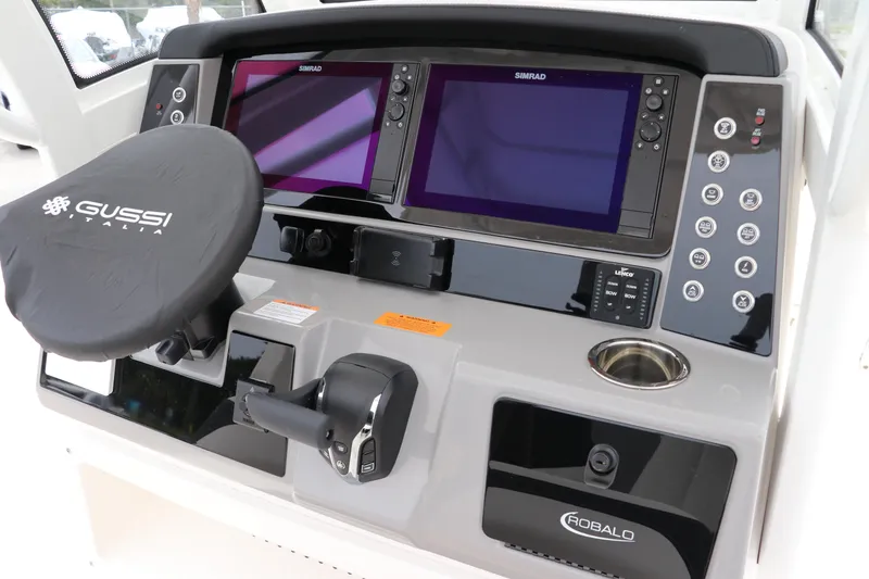 Slide: The Image of 2024 Robalo 266 Cayman boat dashboard with dual Simrad displays and Gussi steering wheel. - 17