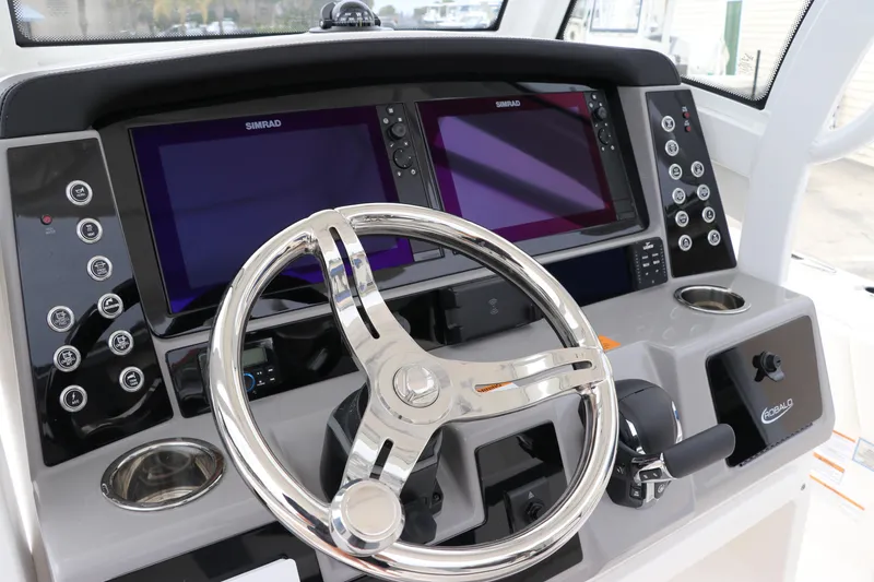 Slide: The Image of 2024 Robalo 266 Cayman boat dashboard with dual Simrad displays and steering wheel. - 18