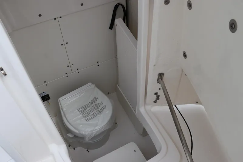 Slide: The Image of 2024 Robalo 266 Cayman boat interior with compact marine toilet. - 23