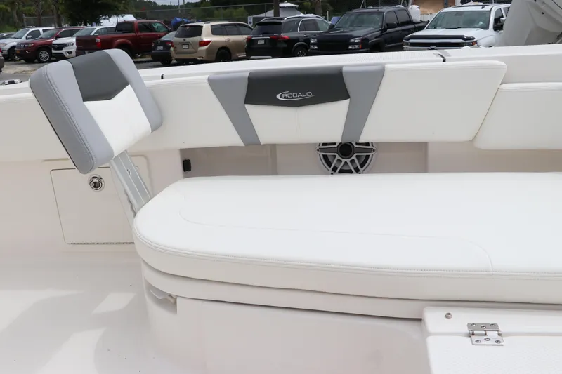 Slide: The Image of 2024 Robalo 266 Cayman boat interior with white cushioned seating and speaker. - 24