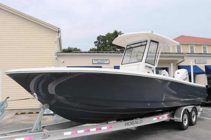 Slide: The Image of 2024 Robalo 266 Cayman boat on trailer, parked outside a building. - 3