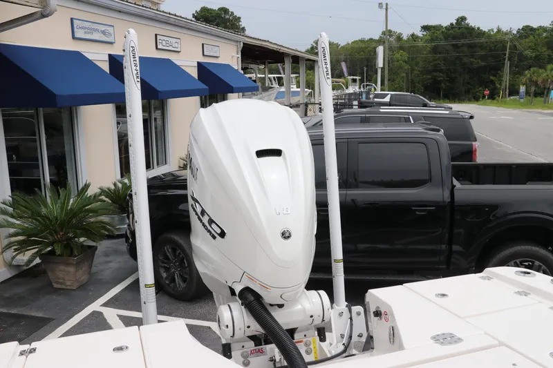 Slide: The Image of 2024 Robalo 266 Cayman boat with powerful outboard motor, parked near dealership. - 8