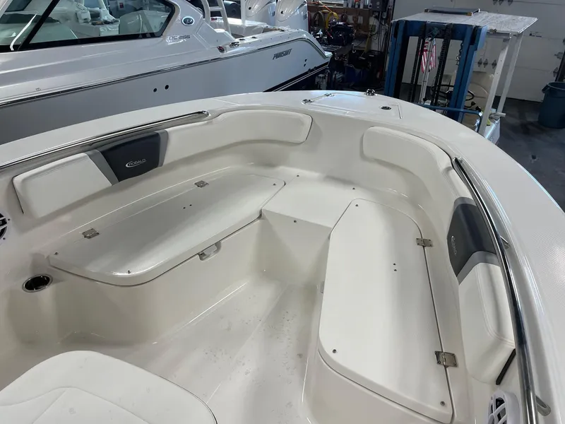 Slide: The Image of 2024 Robalo R200 Center Console boat interior with white seating and storage compartments. - 17