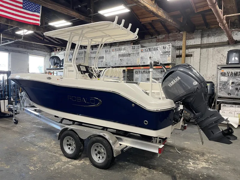 Slide: The Image of 2024 Robalo R200 Center Console boat with Yamaha engine on trailer in warehouse. - 2