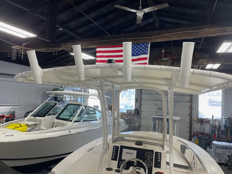 Slide: The Image of 2024 Robalo R200 Center Console boat in a garage with an American flag. - 8