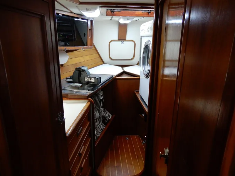 Slide: The Image of 1985 Barnett Offshore yacht interior with wood paneling and compact laundry area. - 10