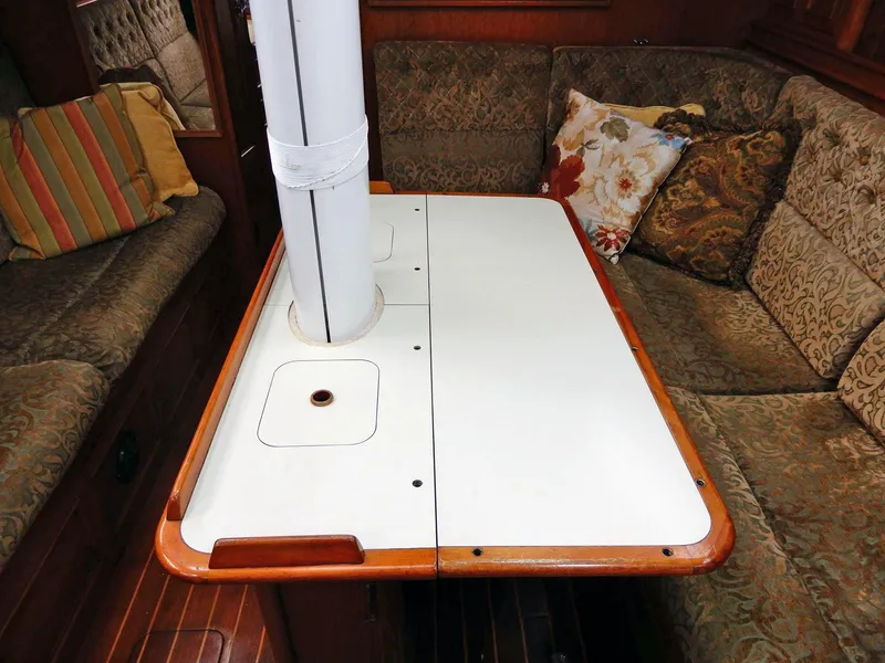 Slide: The Image of 1985 Barnett Offshore yacht interior with cushioned seating and a central table. - 5
