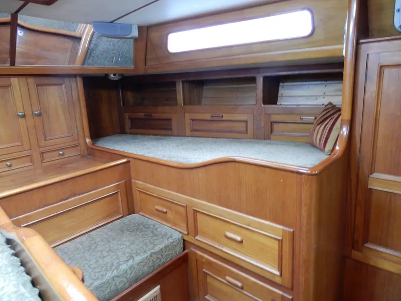 Slide: The Image of 1985 Barnett Offshore yacht interior with wooden cabinetry and cushioned seating. - 7
