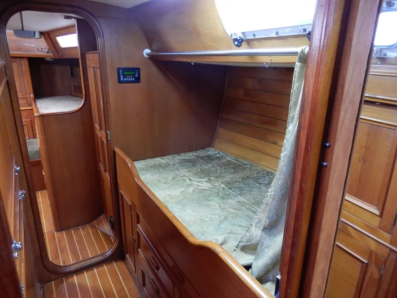 Slide: The Image of 1985 Barnett Offshore yacht interior with wooden finish and cozy sleeping area. - 8