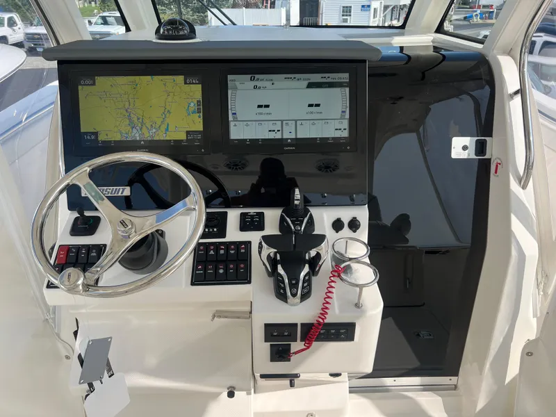 Slide: The Image of 2024 Pursuit S 328 Sport boat dashboard with navigation screens and steering wheel. - 16