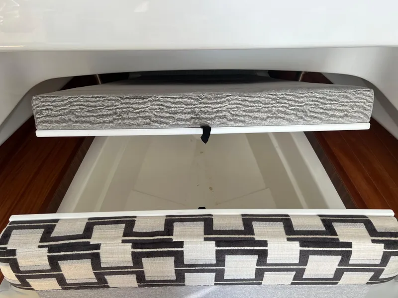 Slide: The Image of 2024 Pursuit S 328 Sport interior storage compartment with patterned cushions. - 19